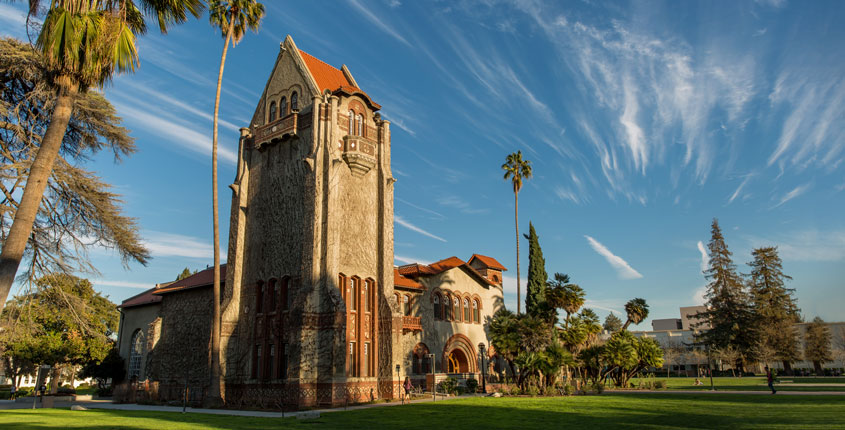 Tower Hall at San José State University on a sunny day, framed by palm trees